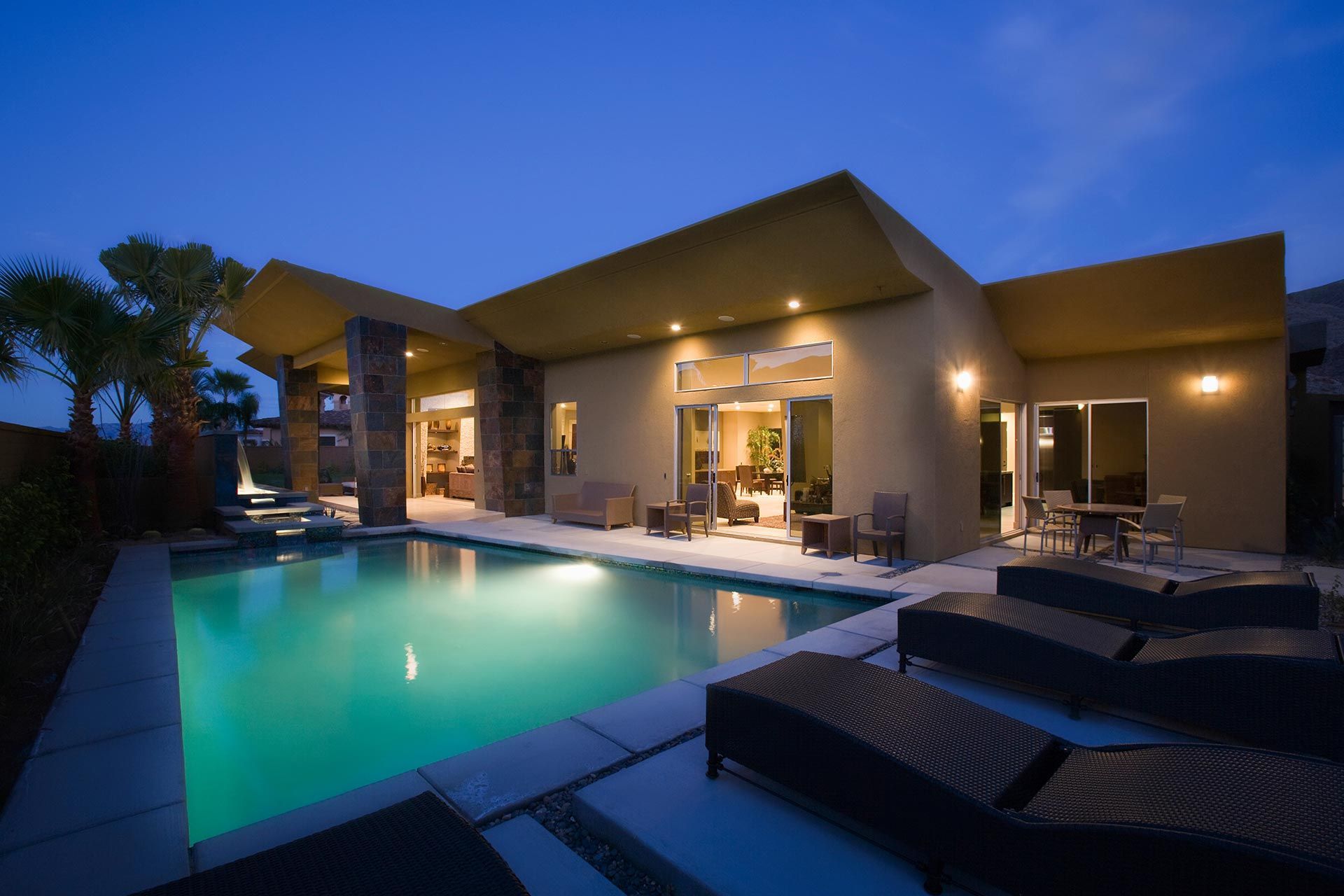 Home exterior and pool area illuminated with low-voltage landscape lighting.