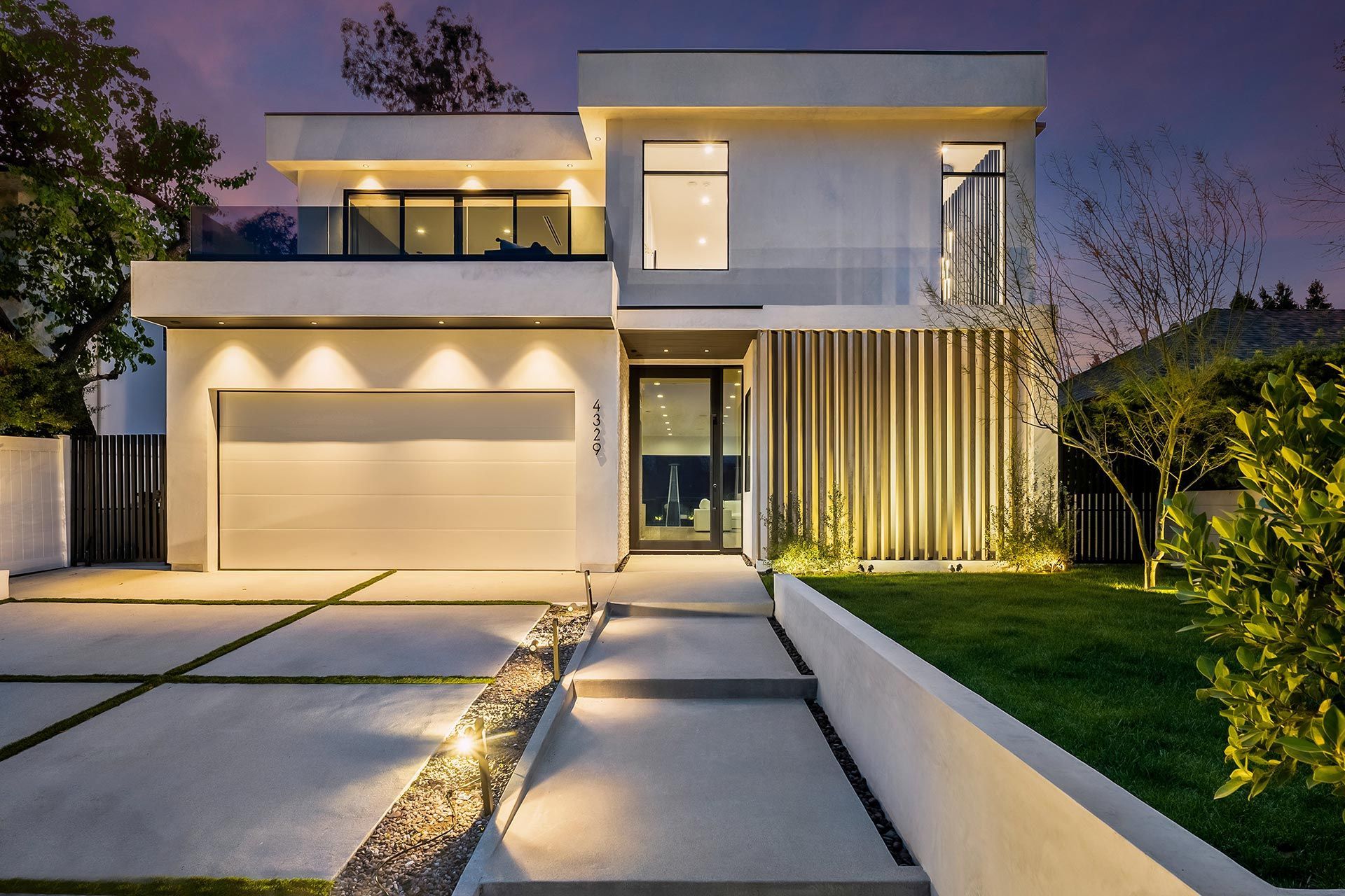 Modern home exterior with low-voltage pathway and facade lighting.