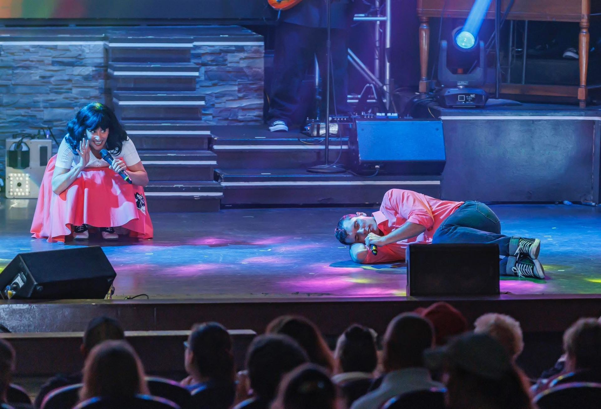 man in cowboy hat with microphone shaking hands with audience members 
