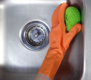 Someone from our commercial cleaning team scrubbing a steel sink in Honolulu, HI