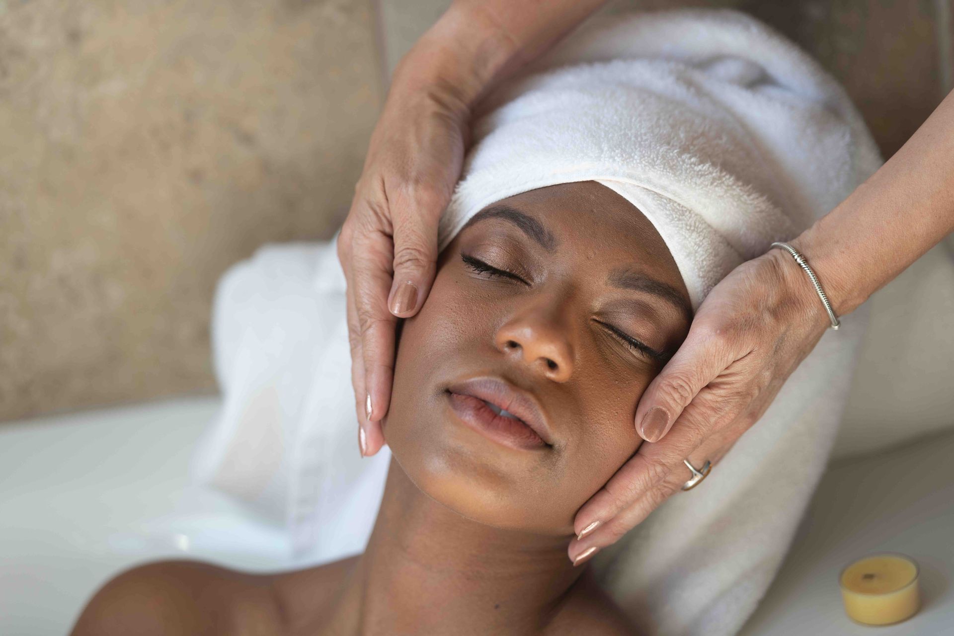 A woman is getting a facial massage at a spa.