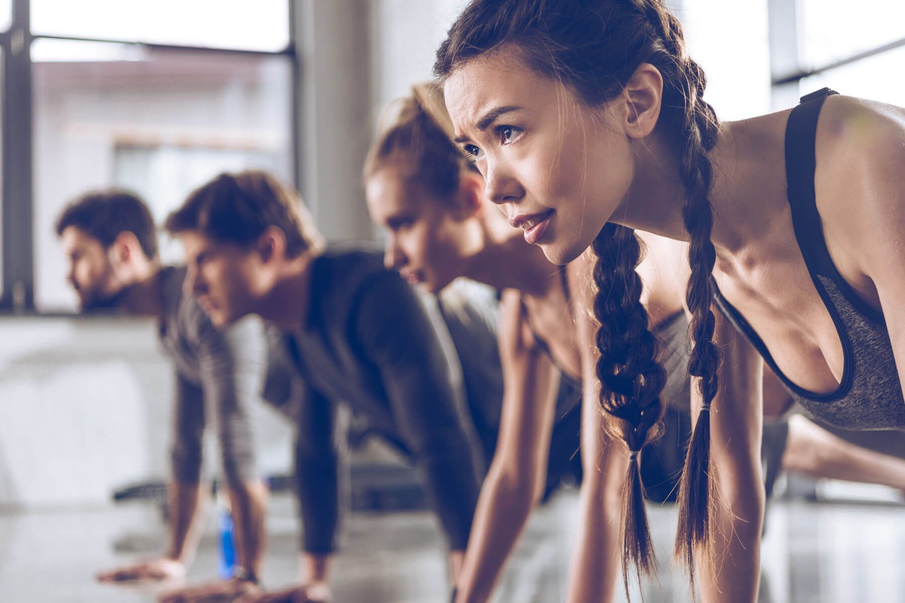 A group of people are doing push ups in a gym.