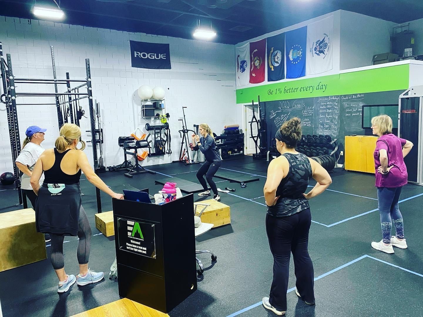 A group of women are standing in a gym.