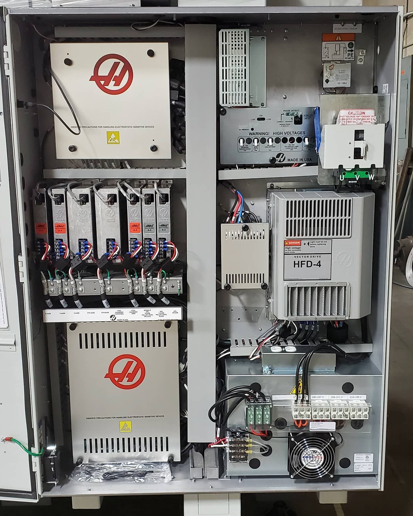 Metal cabinet with various electronic components. Haas machine parts and other industrial equipment.