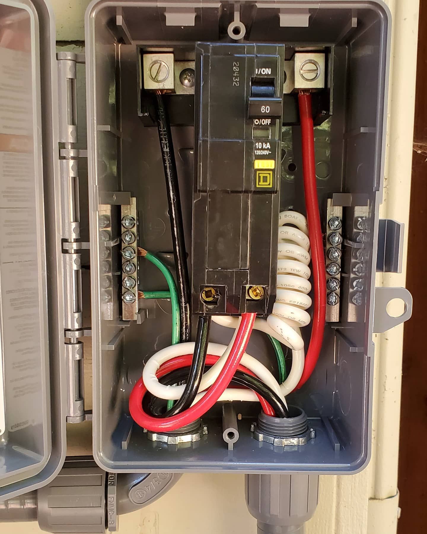 Electrical junction box with black, white, and red wires connected to a breaker and terminals.