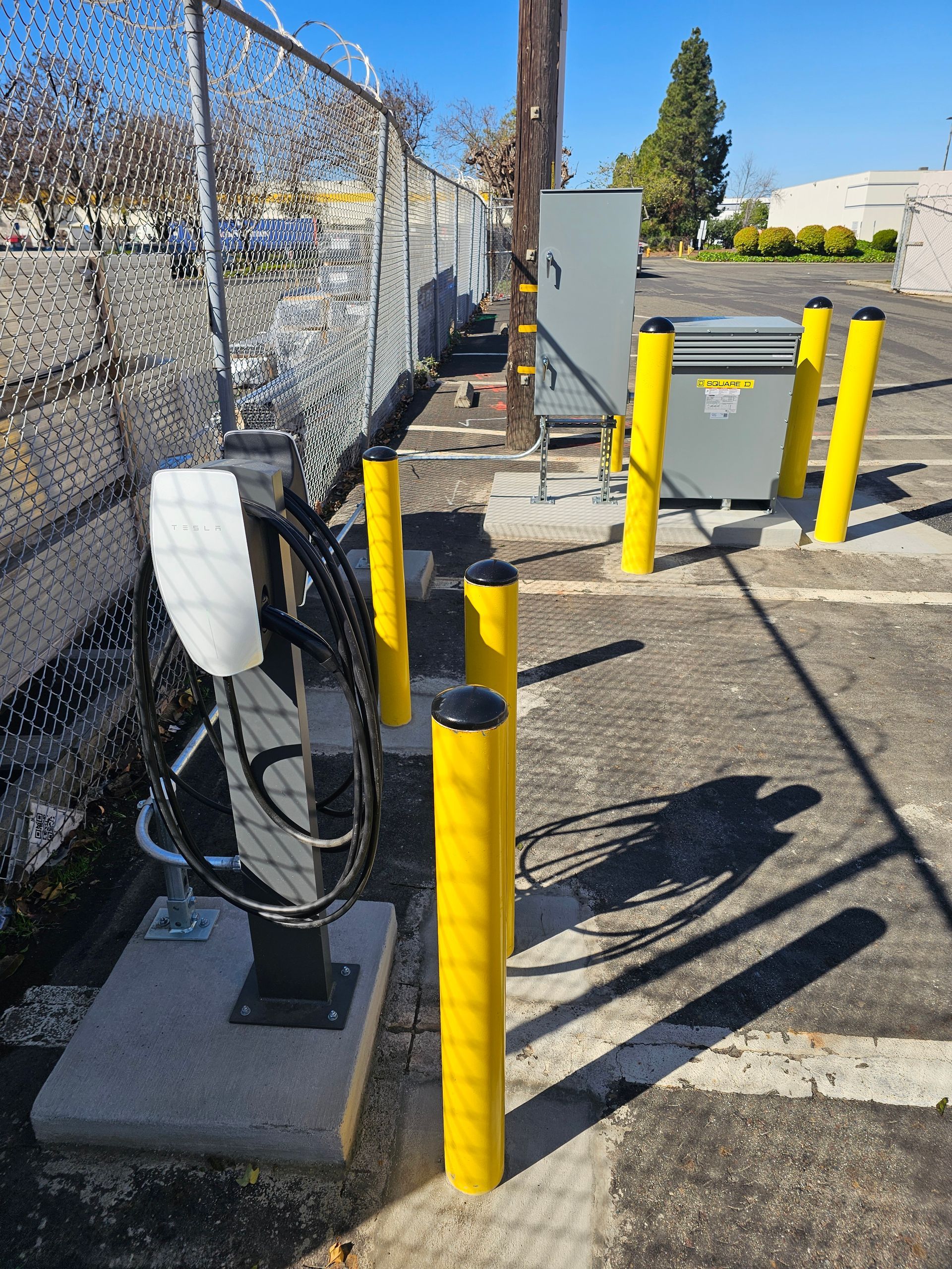 A manufacturing workshop with various workstations, tools, and assembly lines. Fluorescent lighting illuminates the space.