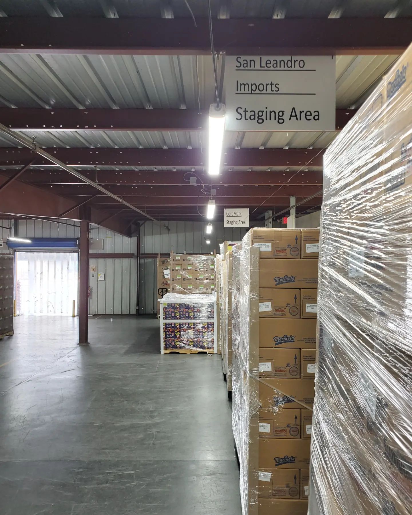 Warehouse interior, boxes on pallets wrapped in plastic. 