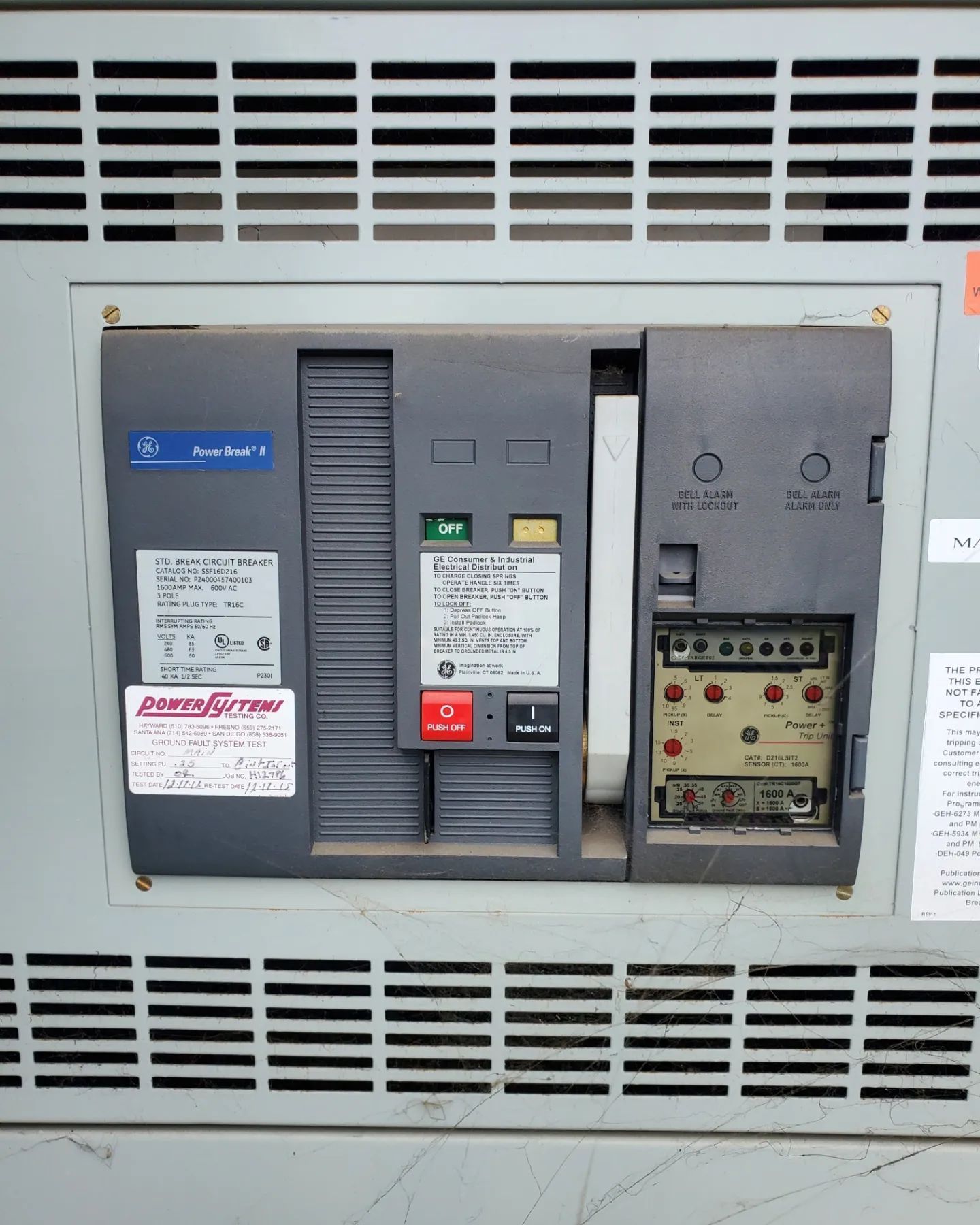 Electrical panel with a circuit breaker, buttons, and various labels, likely industrial setting.