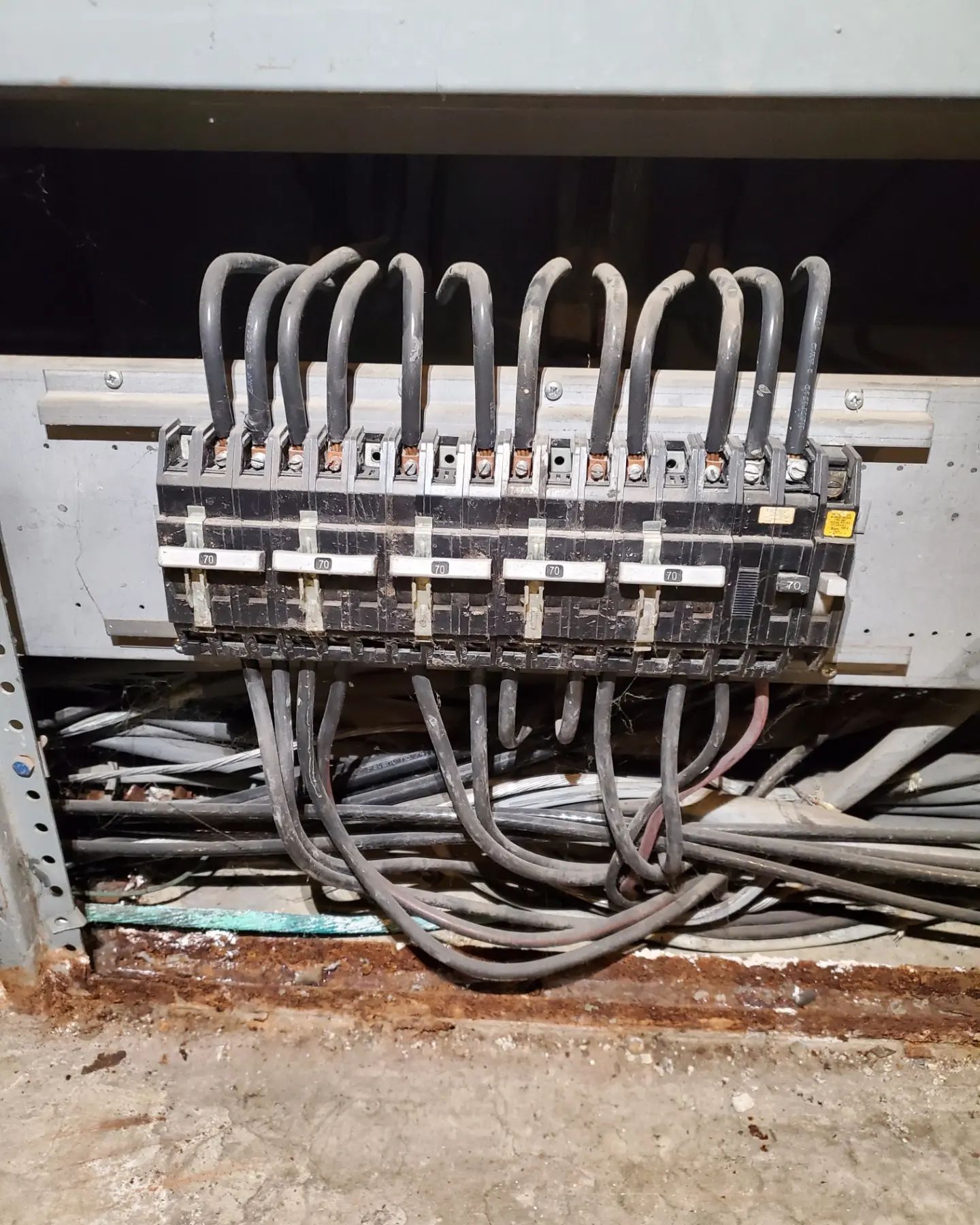 Electrical circuit breakers with attached wires in a dimly lit, possibly industrial setting.