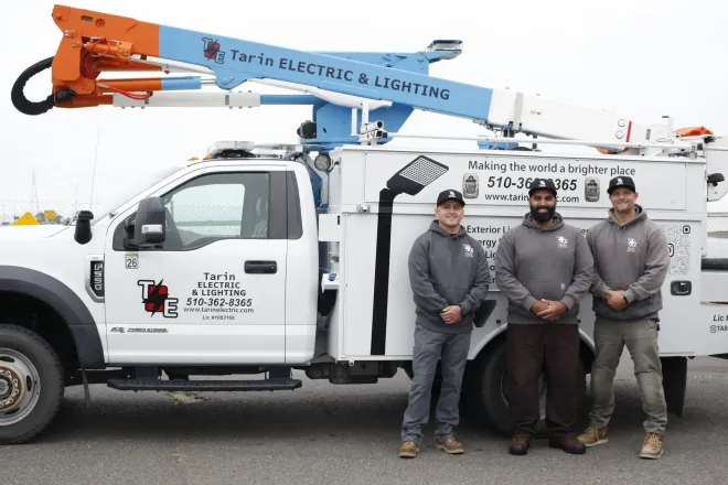Electrical panel with circuit breakers and wiring inside a metal enclosure.