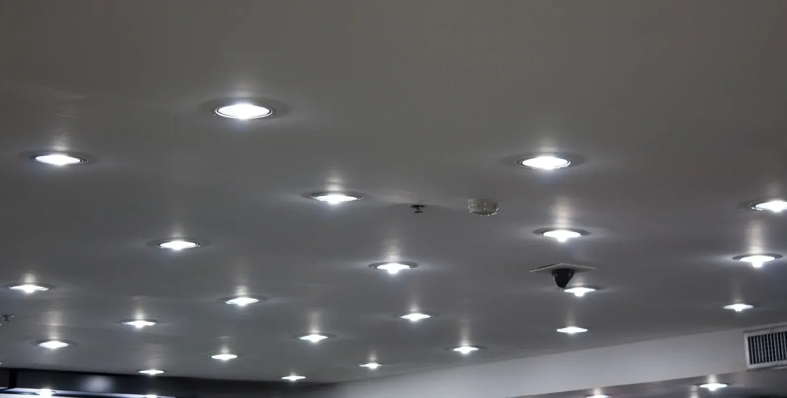 White ceiling with many recessed, bright lights.