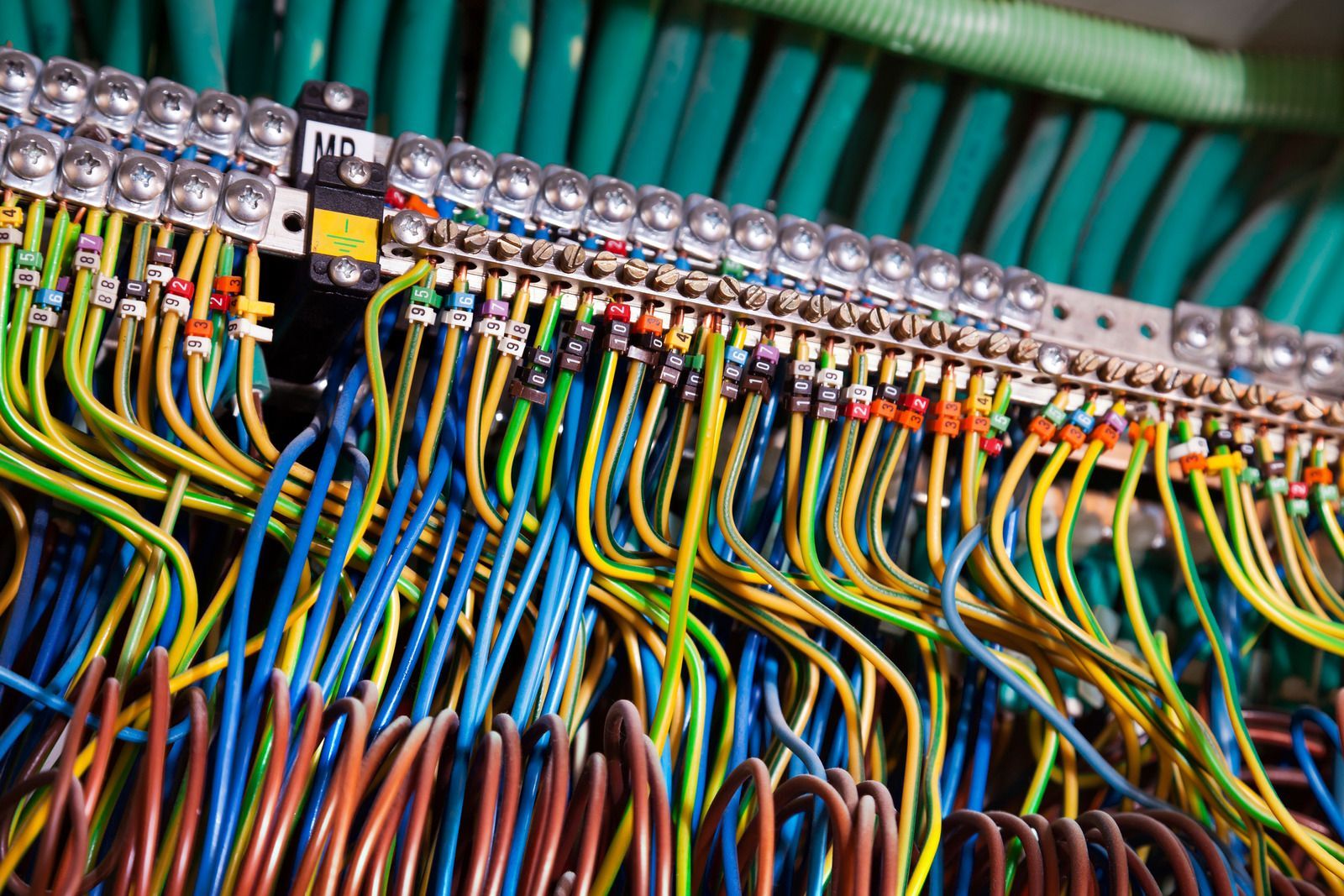 Close-up of a wiring panel with numerous multicolored wires connected to terminals.