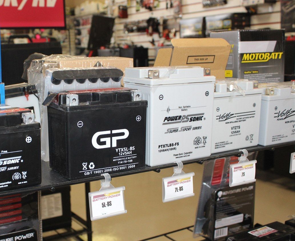 Batteries on display in a store, various sizes and brands, with price tags attached.