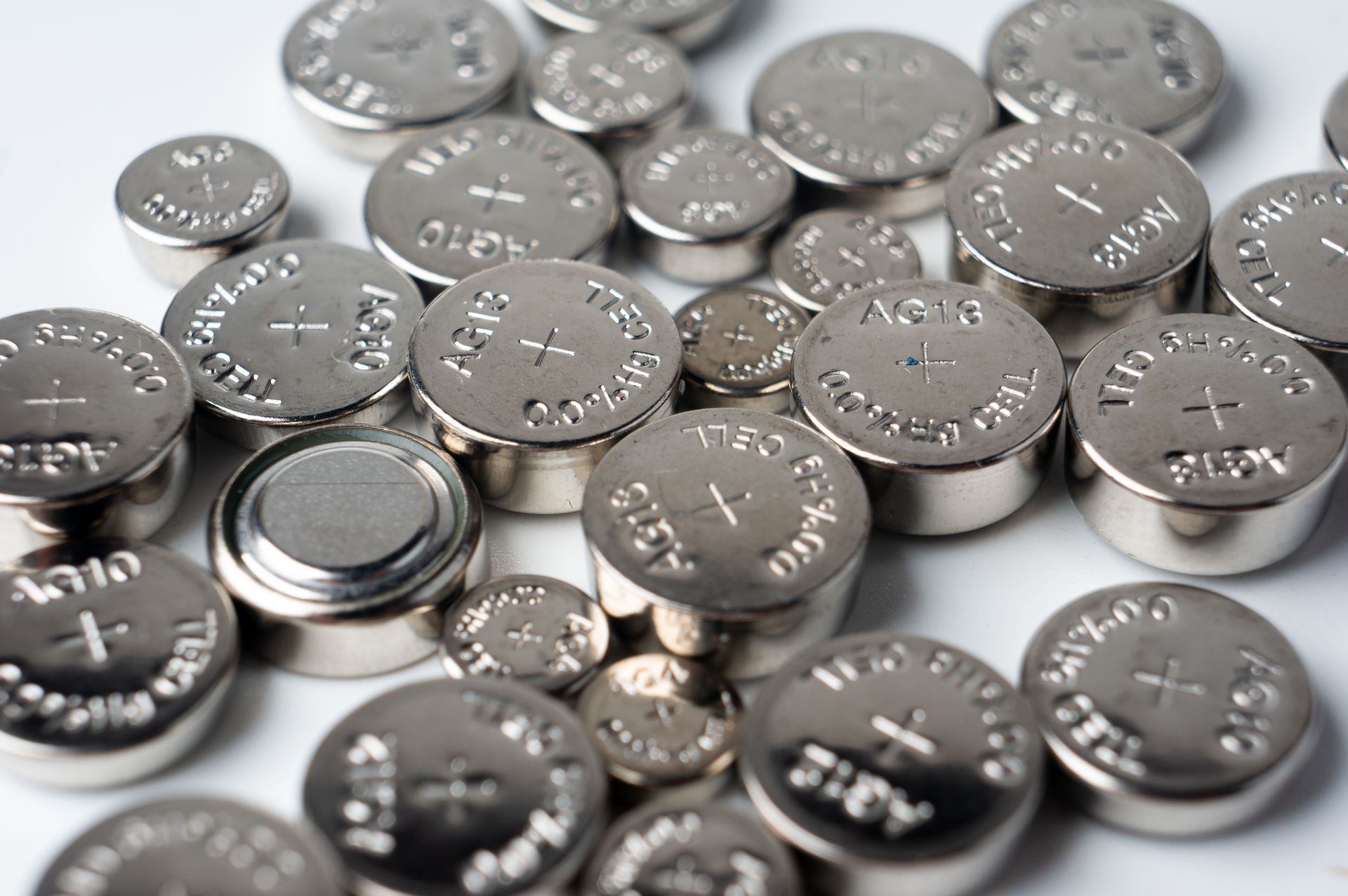 Close-up of a grid of black car batteries, with red and black terminals.