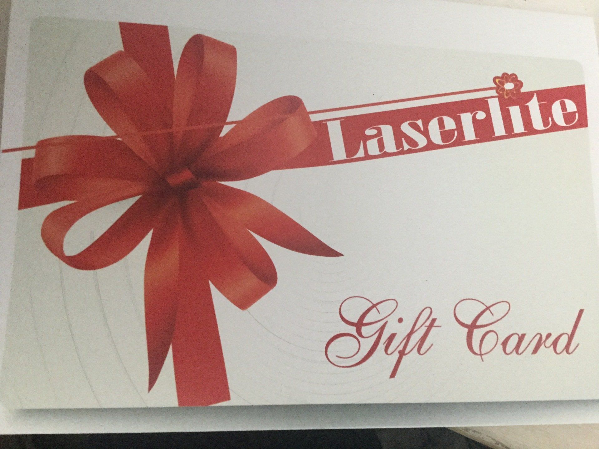 a laserlite gift card with a red bow