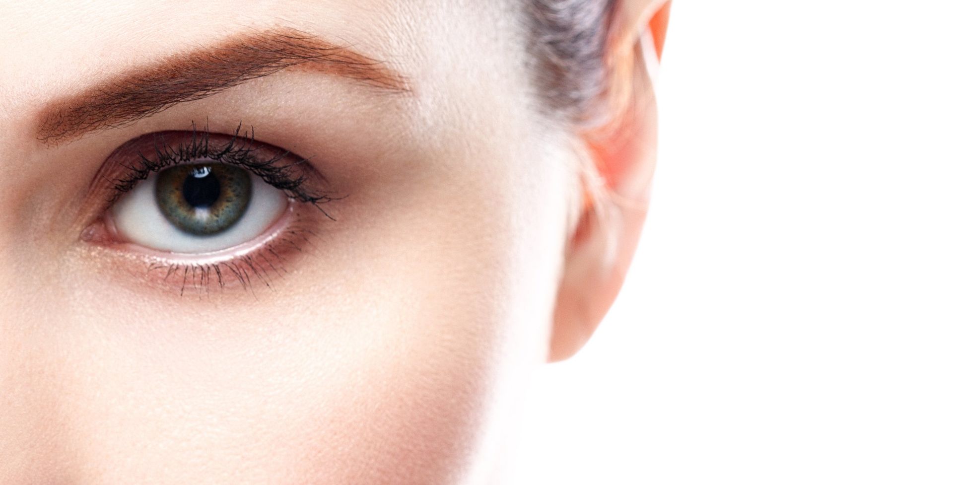 a close up of a woman's eye and ear on a white background.