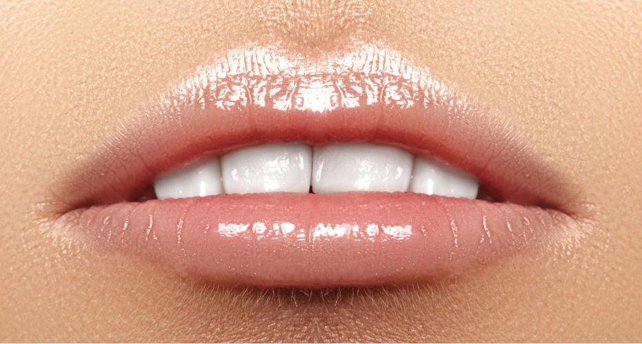a close up of a woman 's lips with white teeth .