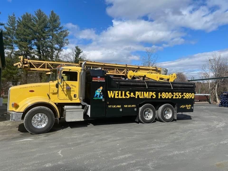 A wells and pumps truck is parked in a parking lot