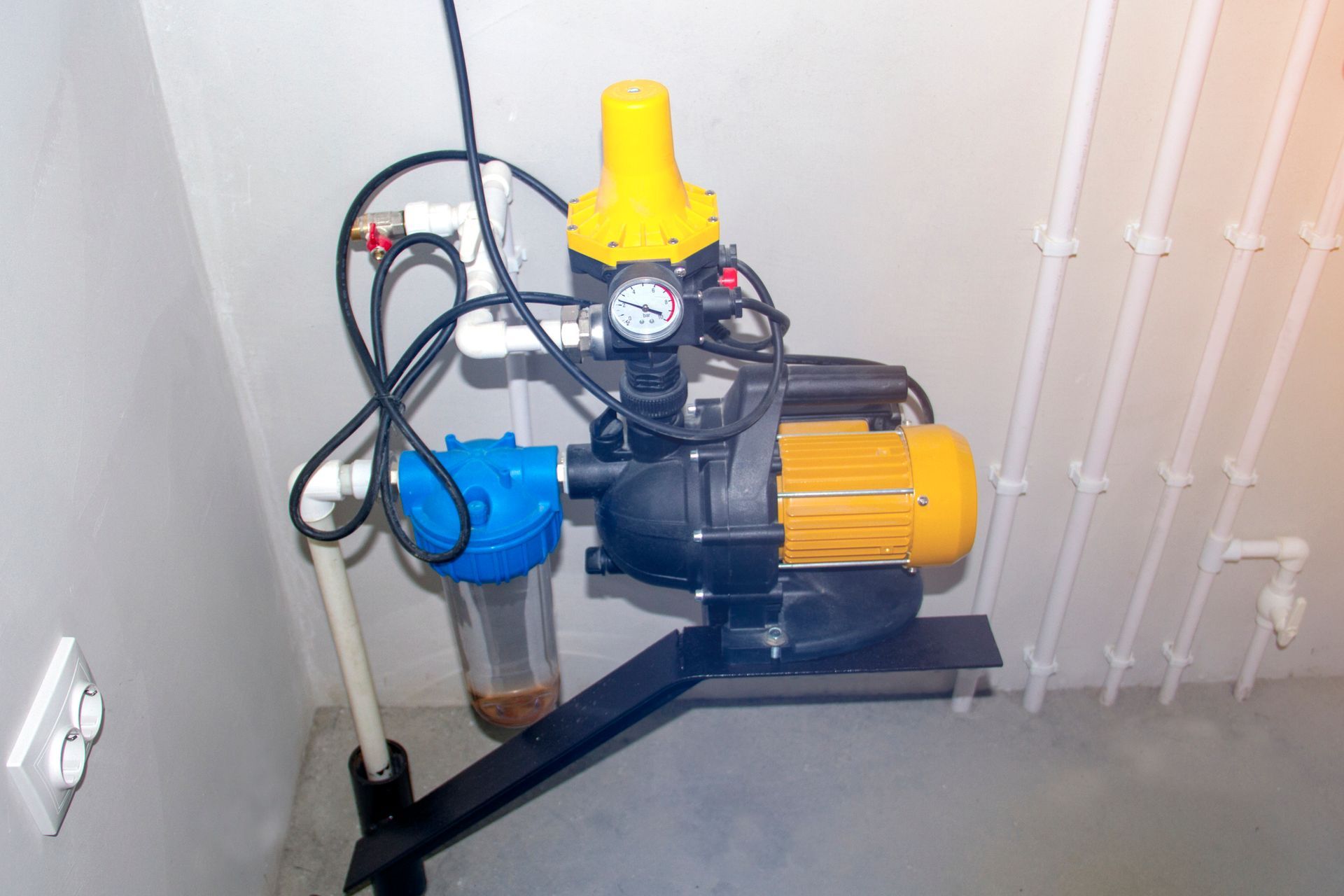 A water pump is sitting in a room next to a wall.