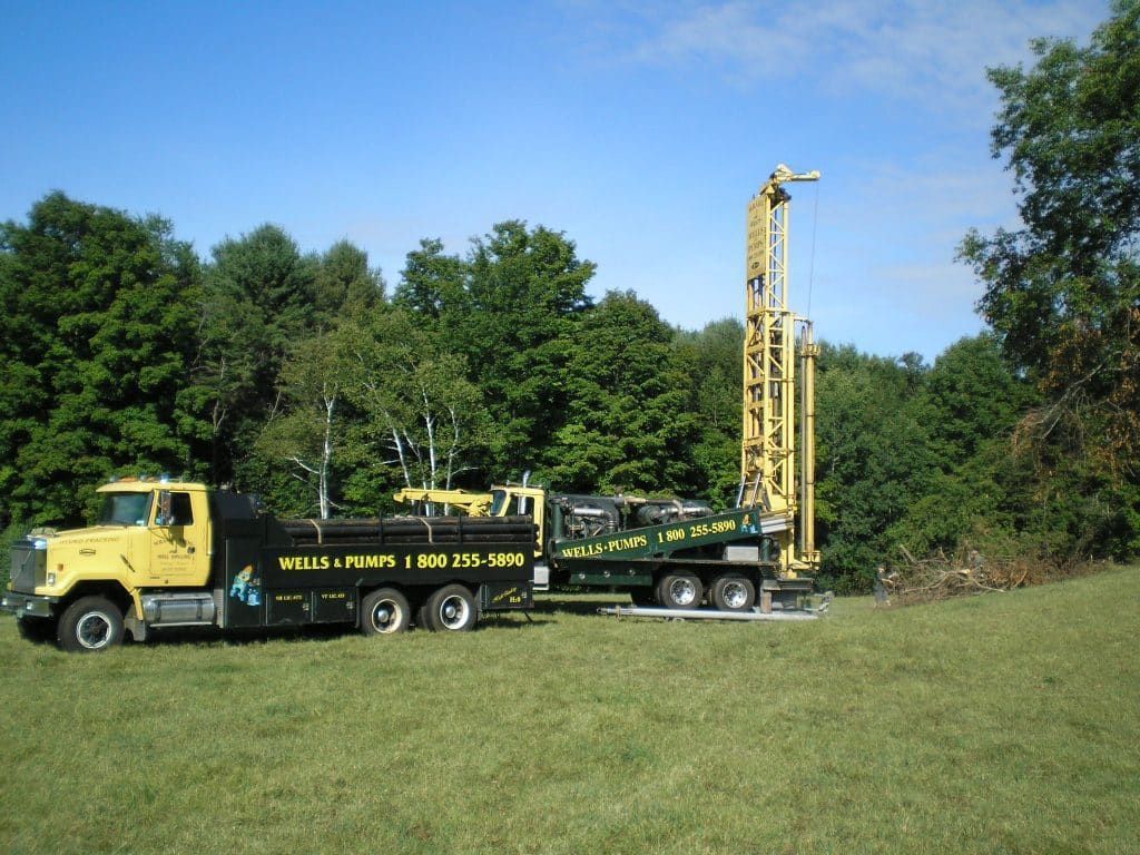 A yellow truck that says fields pumps is parked in a grassy field
