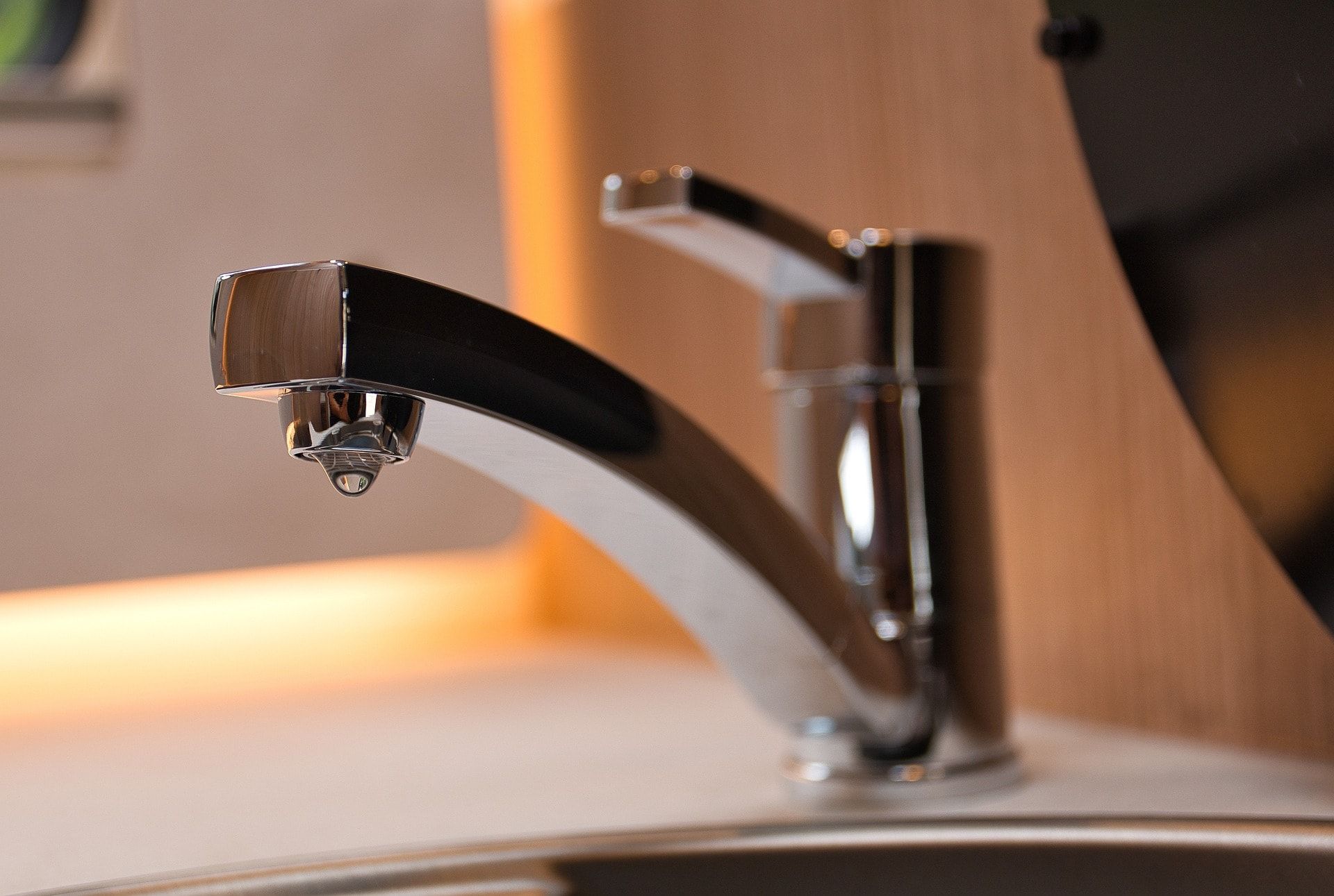 A faucet with a drop of water coming out of it