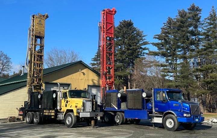 Two trucks are parked next to each other in front of a building.