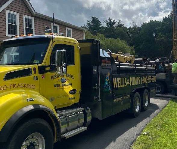 A yellow truck is parked in front of a house.