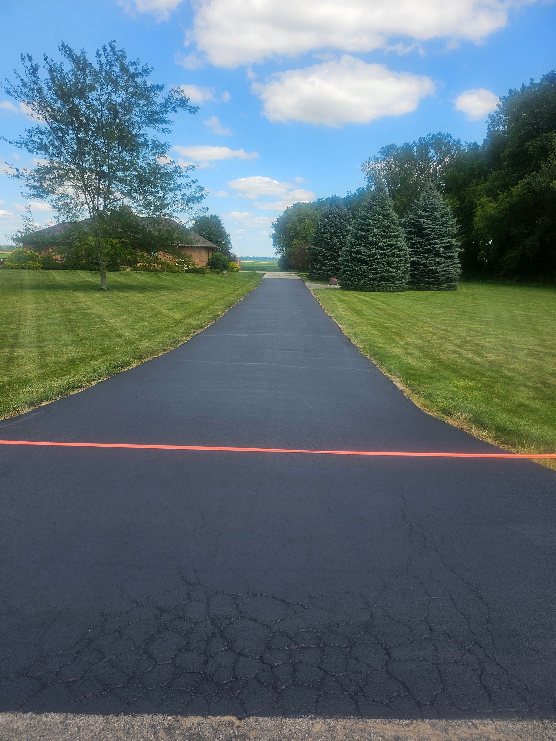 A road that is going through a grassy field