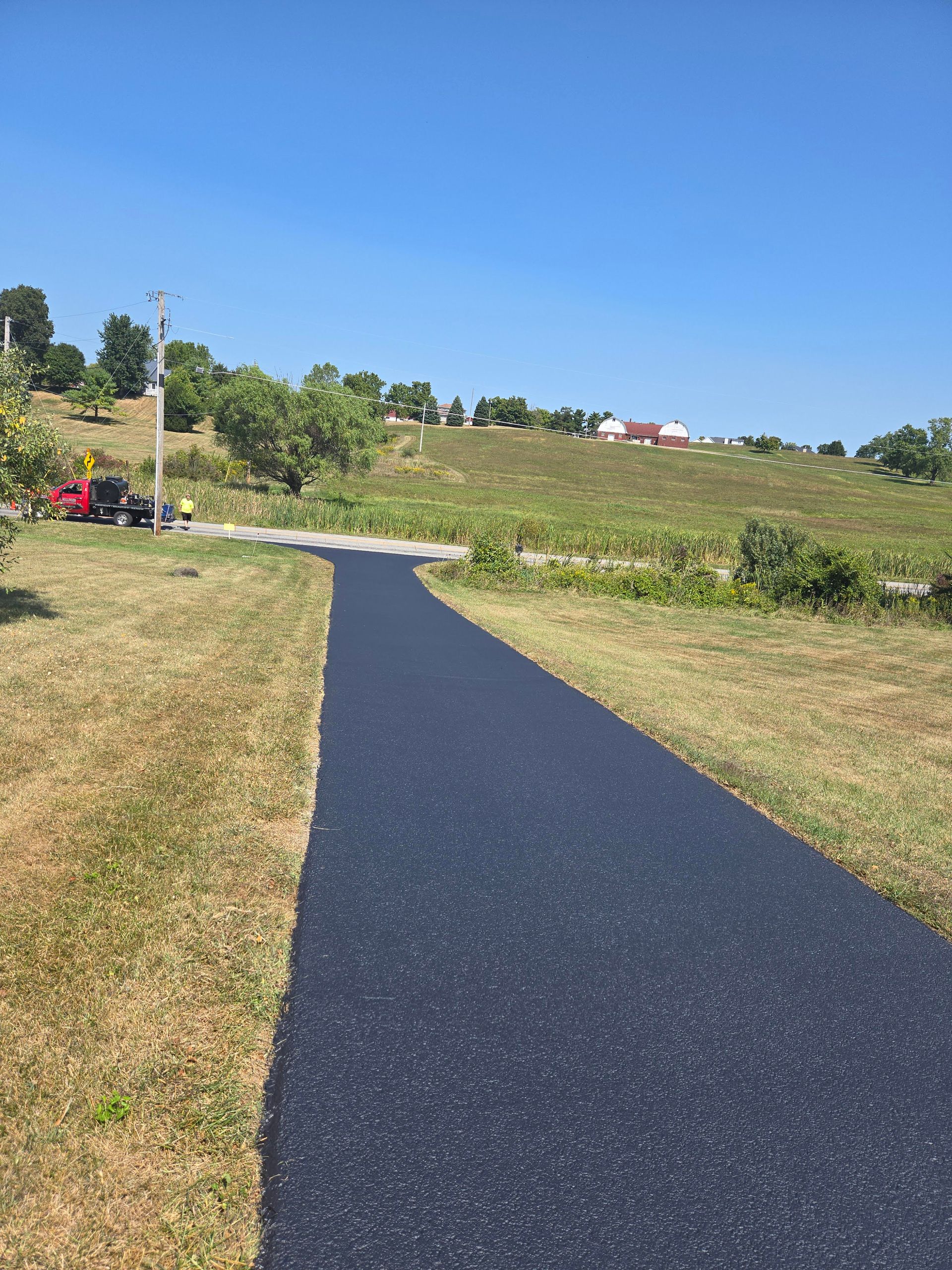 A road that is going through a grassy field