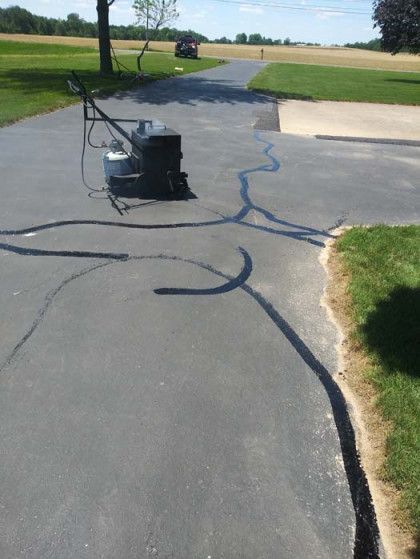 A vacuum cleaner is sitting on the side of a driveway.