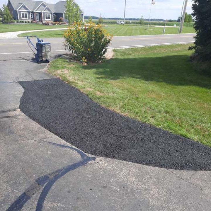 A driveway is being paved in front of a house.