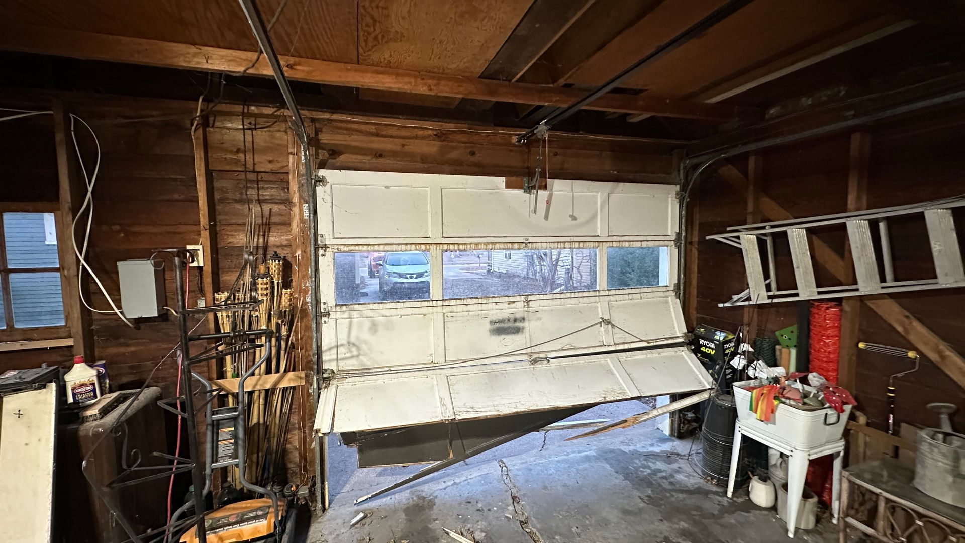 A worker in workwear operates an industrial sectional garage door inside a warehouse.