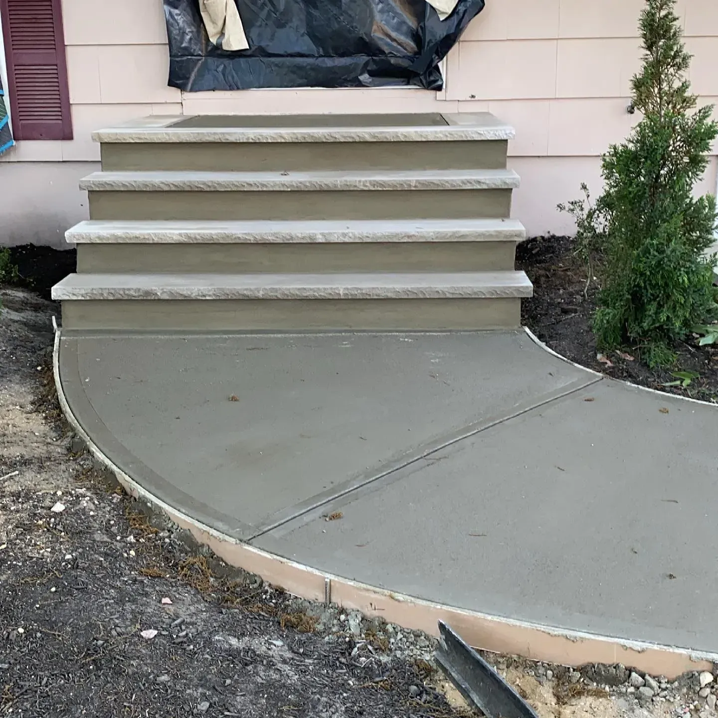 Concrete steps and walkway leading to a house entrance. Newly poured concrete.