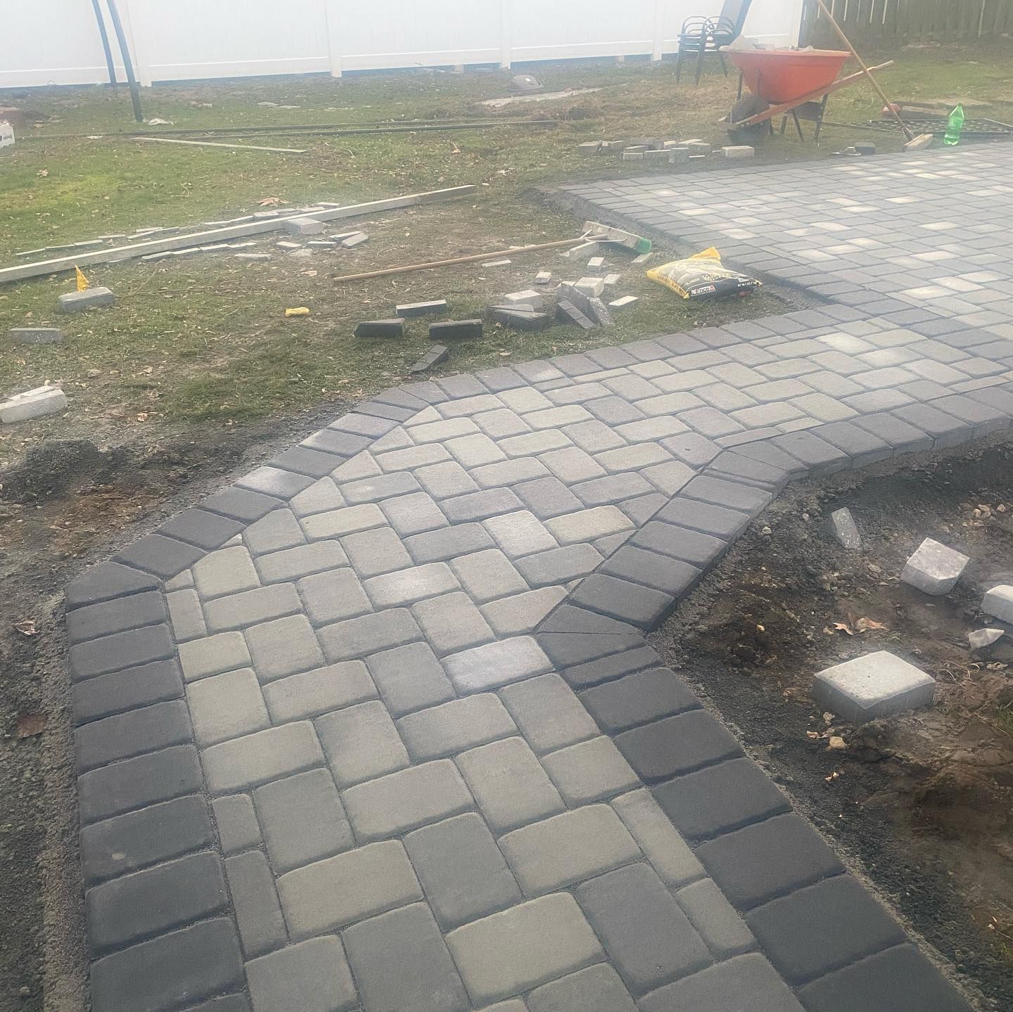 Pathway construction with gray and dark gray paving stones.