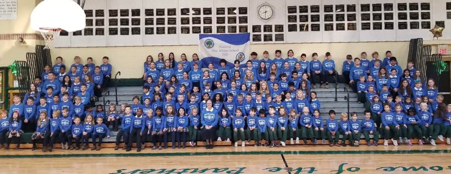 A large group of people in blue shirts are posing for a picture