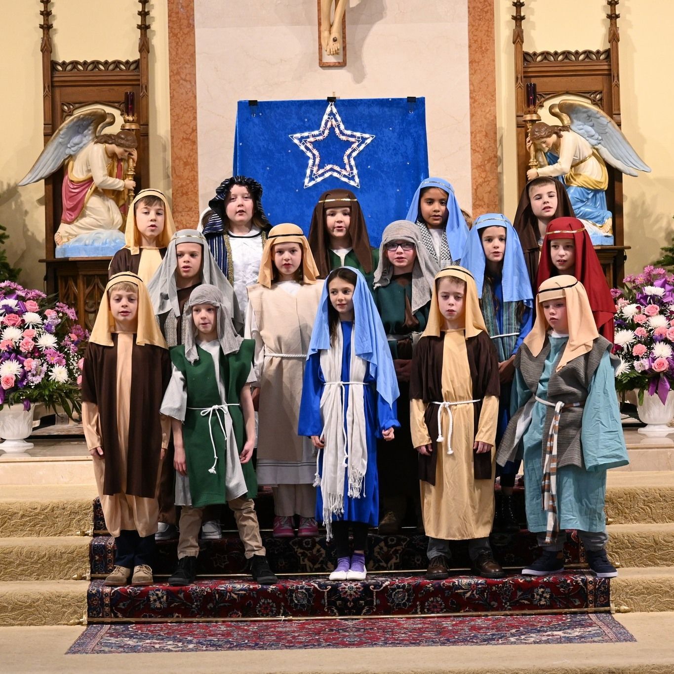 A group of children dressed in nativity costumes are posing for a picture