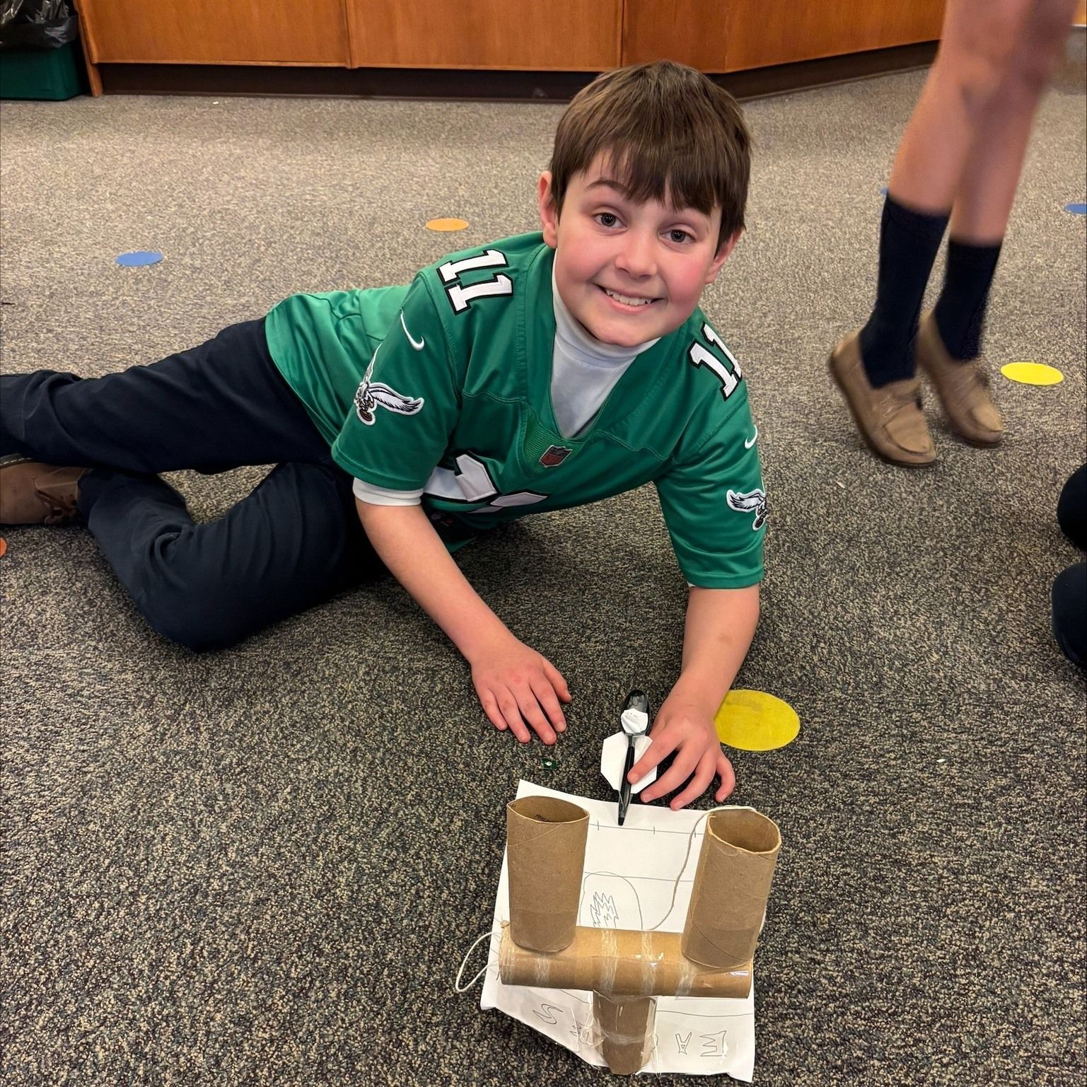 A boy wearing a green jersey with the number 11 on it
