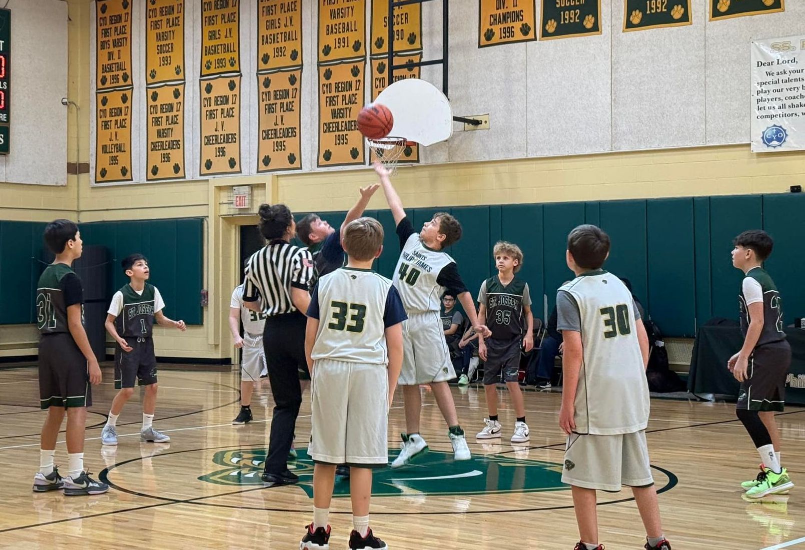 A group of young boys are playing basketball in a gym.