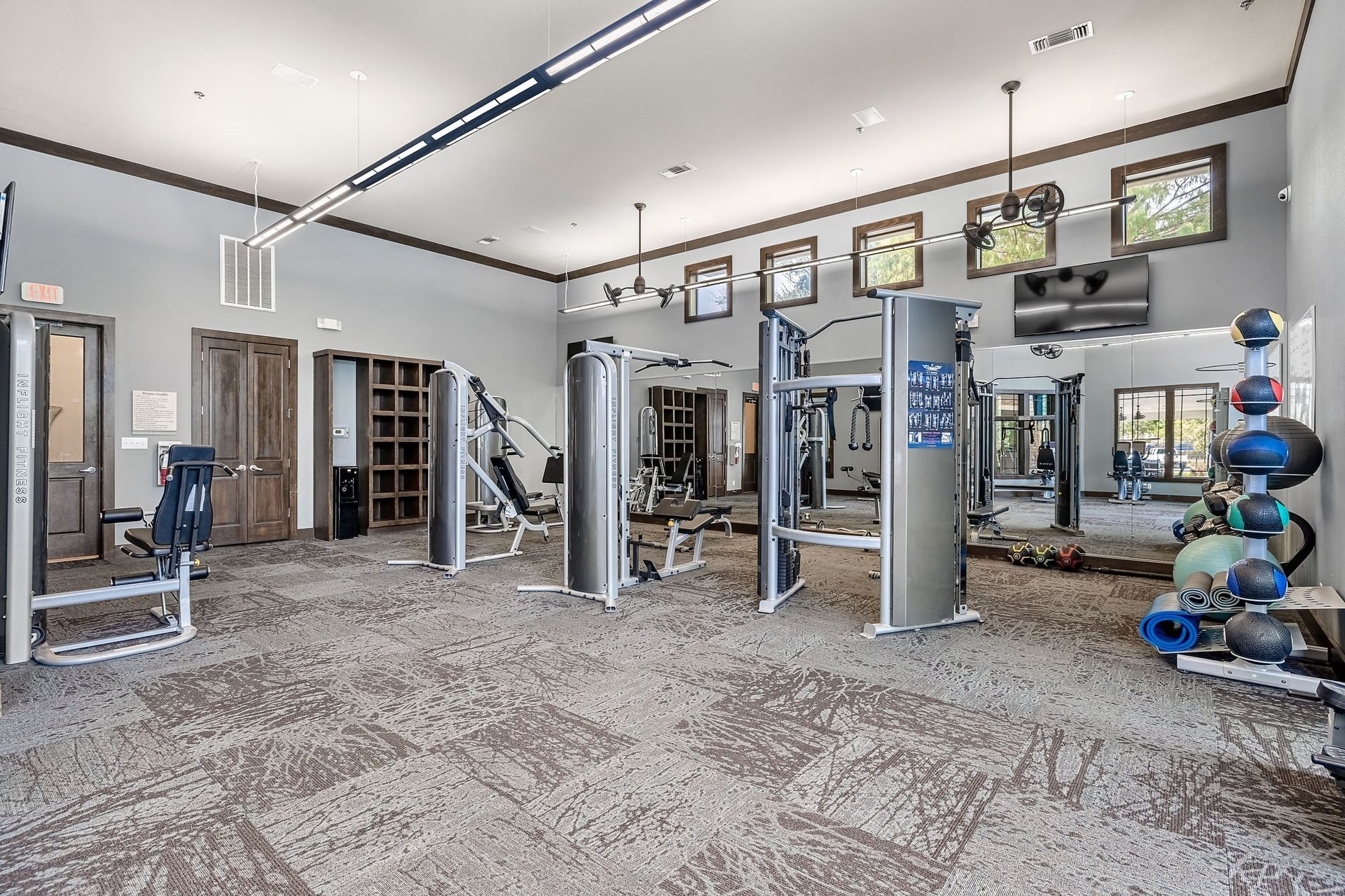 a gym with a lot of weights and cardio equipment and a tv