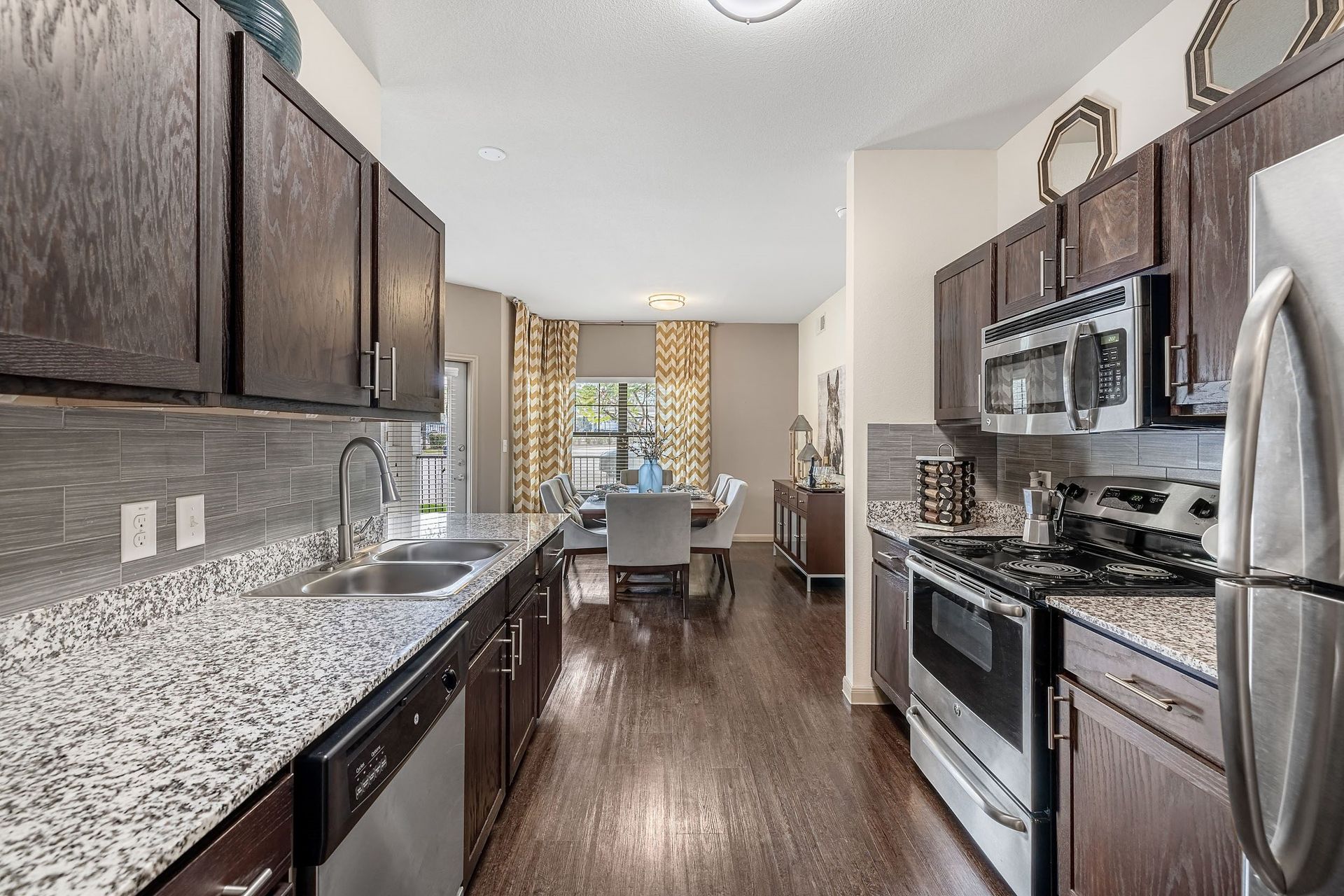 a view of a kitchen and a living room with wood floors