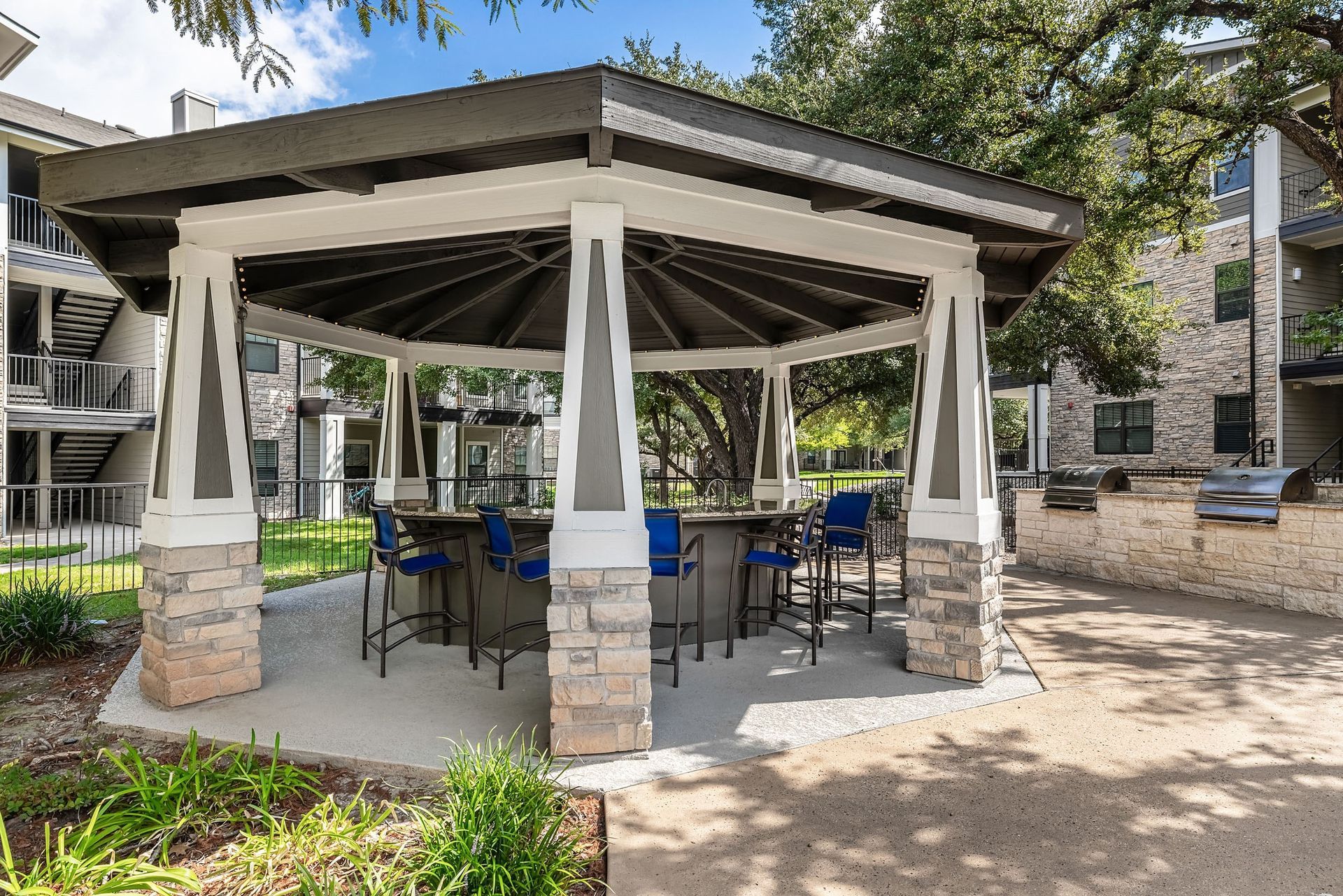 a patio with a gazebo with a table and chairs