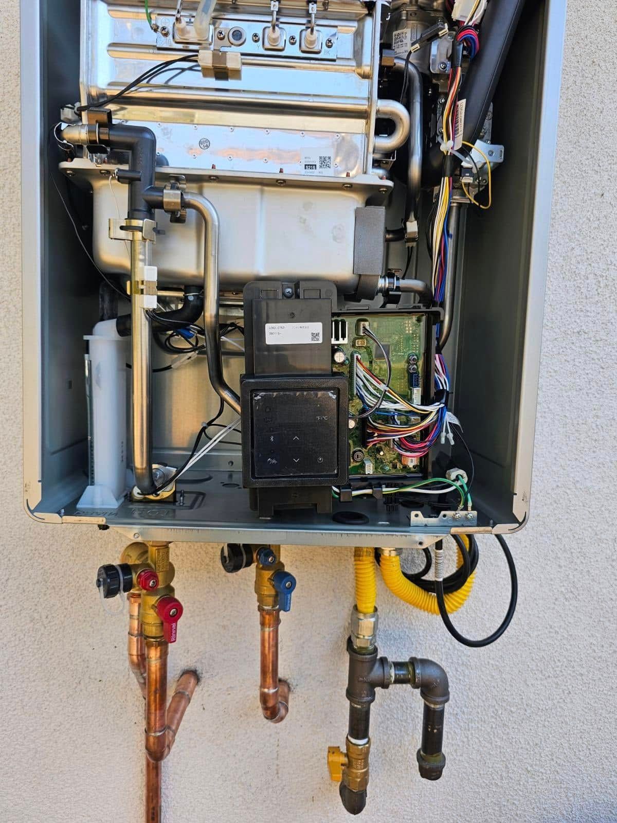 The inside of a water heater with copper pipes attached to it
