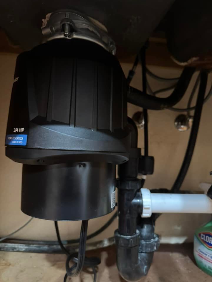 A garbage disposal is under a sink in a kitchen.
