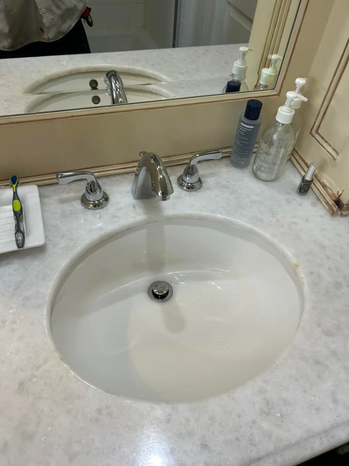 A bathroom sink with a mirror and soap dispensers on the counter.