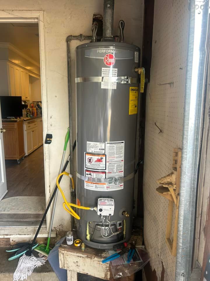 A water heater is sitting on top of a wooden stool in a garage.