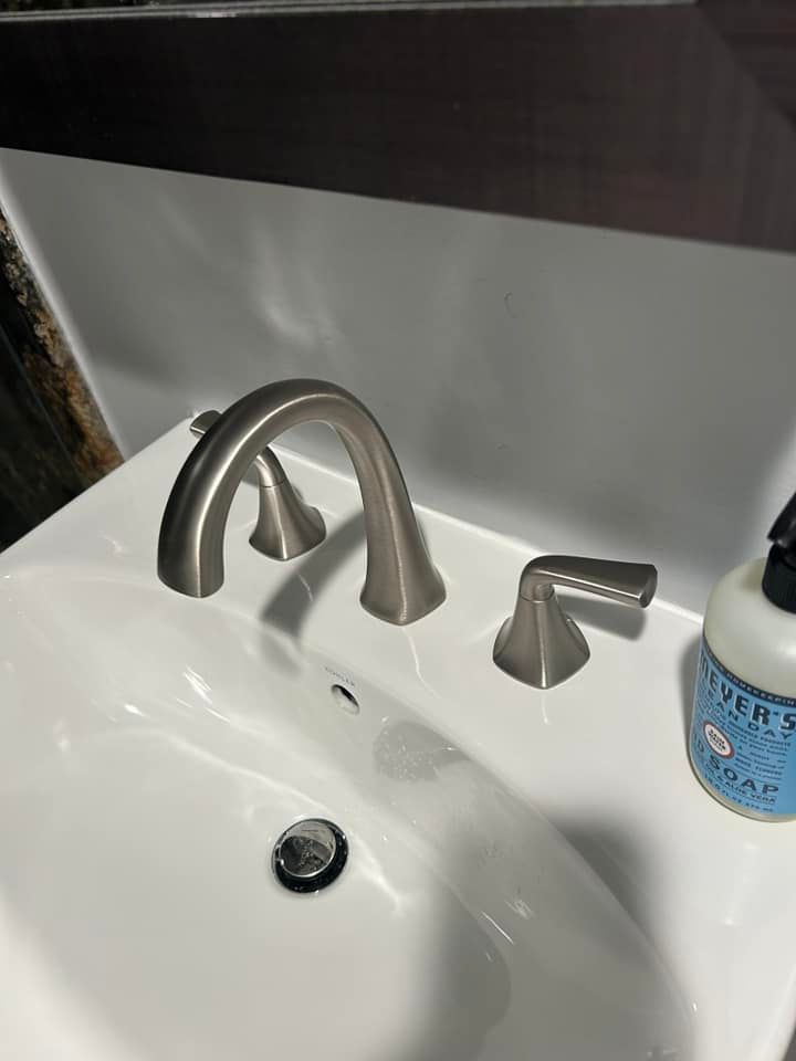 A bathroom sink with a soap dispenser next to it.