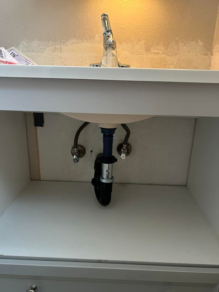 A bathroom sink with a faucet underneath it in a cabinet.
