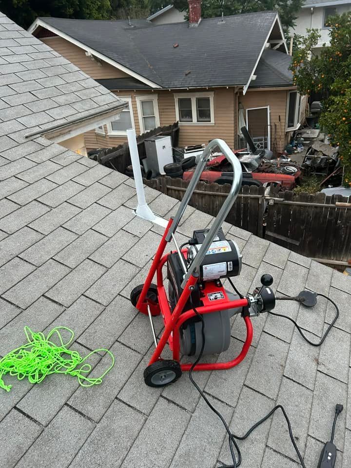 A drain cleaner is sitting on the roof of a house