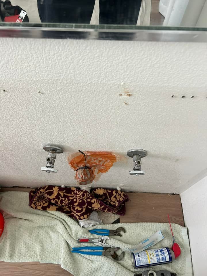 A person is standing in front of a bathroom sink.