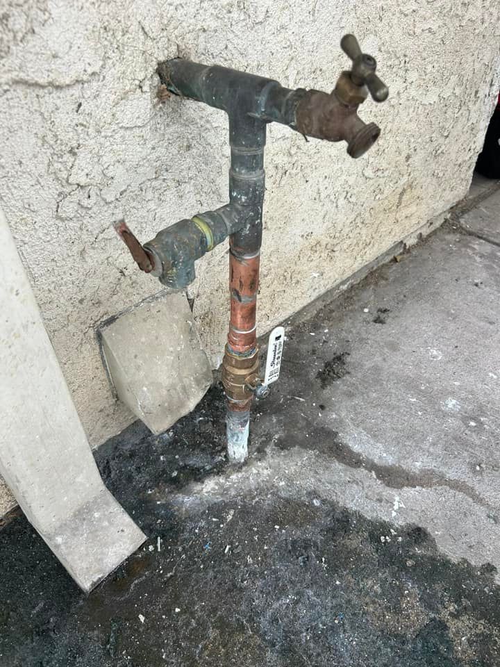 A rusty water faucet is attached to a wall.